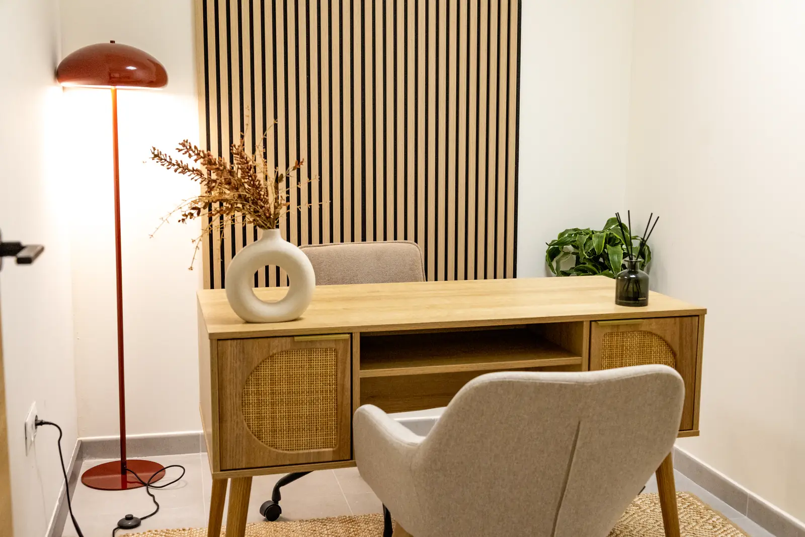 Despacho de psicólogo en Málaga con escritorio de madera, lámpara de diseño y sillón de terapia