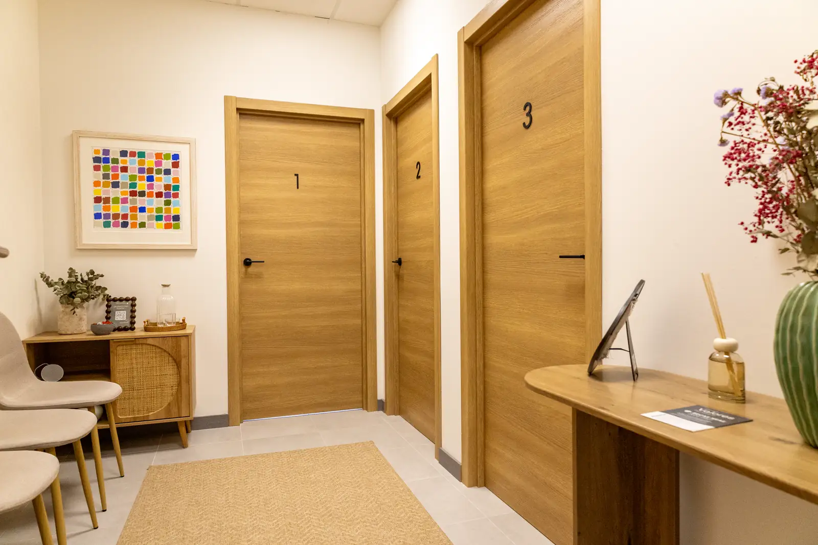 Pasillo de consultas del centro de psicología en Málaga con puertas numeradas y zona de espera