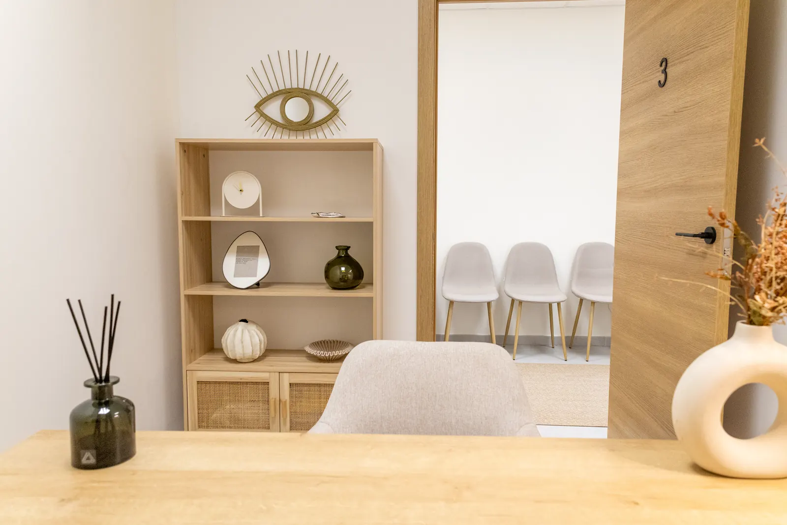Zona de espera del centro de psicología en Málaga con decoración cálida y puerta de consulta